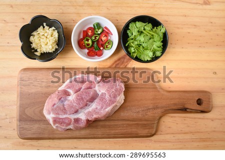 Raw pork on board and vegetables