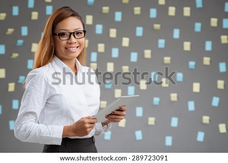 Beautiful business woman with tablet computer smiling and looking at the camera