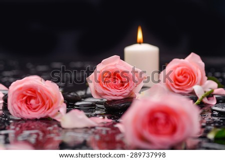 Beautiful orange rose with candle and therapy stones 