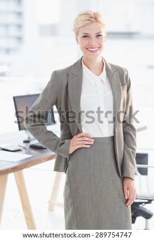 Smiling businesswoman looking at camera in her office