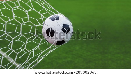 soccer ball in goal with green backgroung Royalty-Free Stock Photo #289802363