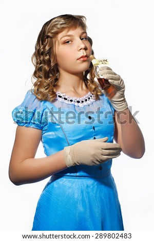 Little girl in a blue dress with bottle "drink me"
