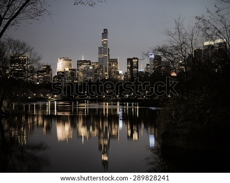 Central Park in dusk buildings reflection in midtown Manhattan New York City, vintage filter