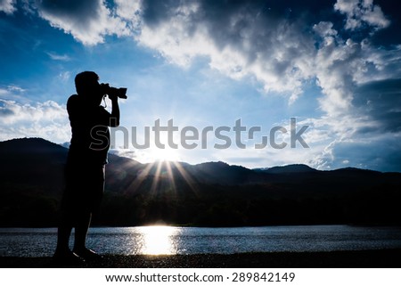 Man take a photograph during sunset silhouette