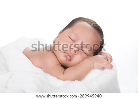 picture of a newborn baby curled up sleeping on a blanket