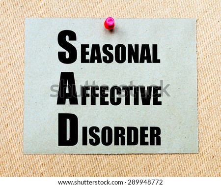 SAD as Seasonal Affective Disorder written on paper note written on paper note pinned with red thumbtack on wooden board. Health conceptual Image Royalty-Free Stock Photo #289948772