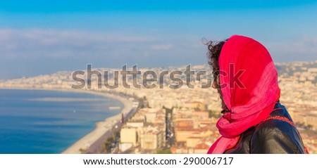 Young woman wearing a red veil overlooking the old city of Nice in France Royalty-Free Stock Photo #290006717