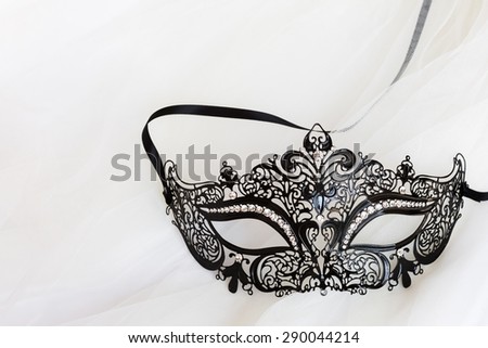Dress up black mask with rhinestones on creamy tulle background