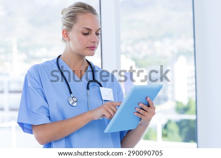 Serious doctor looking at clipboard in medical office