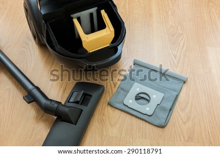 inside Vacuum cleaner and dust bag on the wooden floor Royalty-Free Stock Photo #290118791