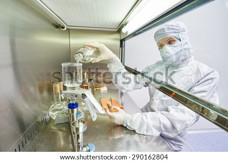 female science researchers in protective uniform and equipment works with dangerous hazard virus material at microbiology laboratory Royalty-Free Stock Photo #290162804