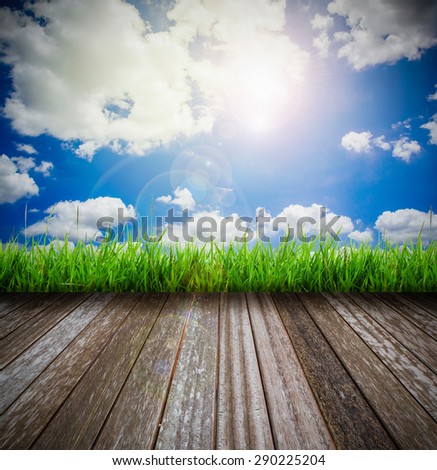 wooden platform with green grass against sun burst background
