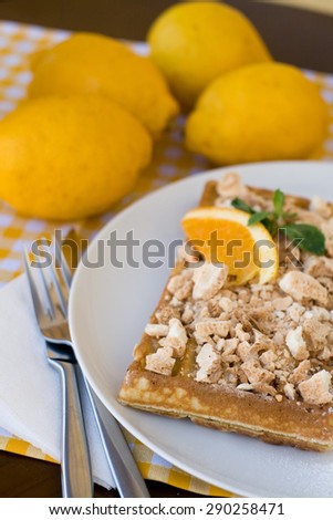 Waffles with meringue, lemon curls and orange slices for breakfast