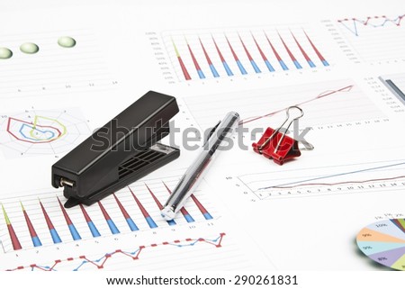 Business still-life of a charts, graphs, paperclips, stapler