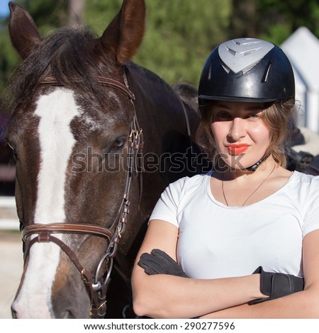 Young woman in Jockey helmet and her horse
