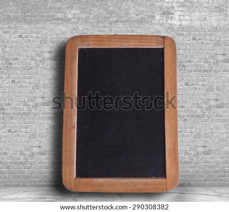 blank blackboard oon the white brick wall