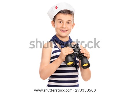 Joyful little boy in a sailor outfit holding a pair of binoculars and looking at the camera isolated on white background