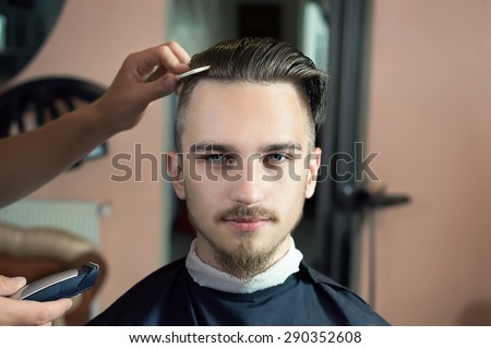 Men's hairstyling and haircutting in a barber shop or hair salon. Royalty-Free Stock Photo #290352608