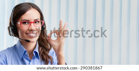 Portrait of happy smiling cheerful young support phone operator in headset, showing okay hand sign gesture at office, with blank copyspace area for slogan or text. Customer assistance service concept.