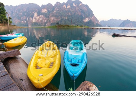 Yellow and blue canoe in a beautiful mountains lake forest and river natural attractions in Ratchaprapha Dam at Khao Sok National Park, Surat Thani Province, Thailand.