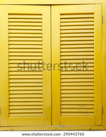 Vintage window with antique retro windows with bright yellow 
 color shutters closing.
