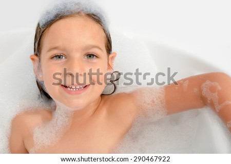 Real adorable toddler girl relaxing in bathtub