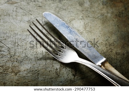 Dining fork and knife on rustic vintage background with copyspace