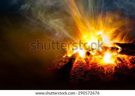 Blaze of catching bonfire and smoke on black background