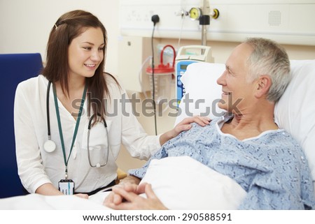 Female Doctor Sitting By Male Patient's Bed
