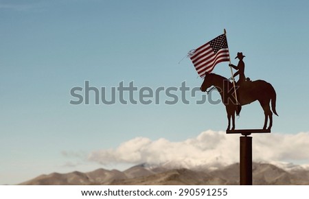 Slightly retro-style picture of a small iron statue of a Horse rider with American Flag.