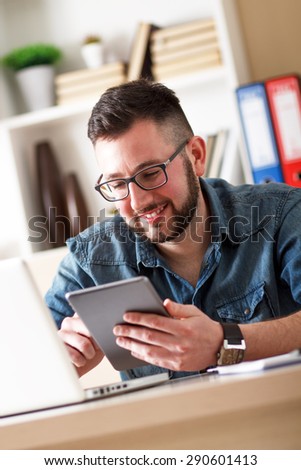 Young businessman looking at tablet in his office