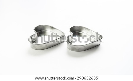 Silver color metal stainless steel heart love shaped pastry baking mould container. Isolated on white background. Concept of tools for lovely cake making. Copy space.