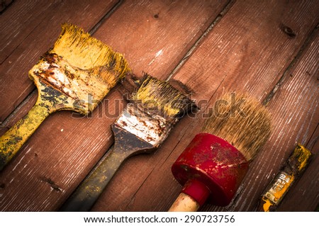 Row of artist paintbrushes closeup on old wooden rustic table, retro stylized