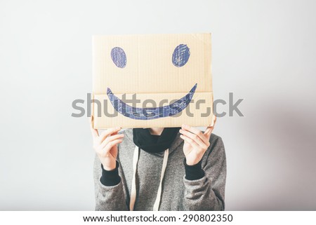 man, holding a picture with a cheerful and happy smiley