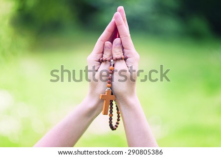 Hands of a woman Praying with Rosary
