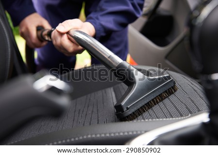Man Hoovering Seat Of Car During Car Cleaning Royalty-Free Stock Photo #290850902