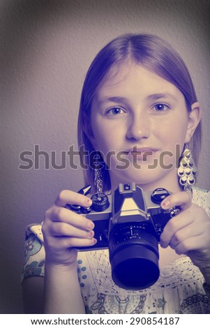 Instagram portrait of young girl teenager photographer holding vintage old camera shooting photographs