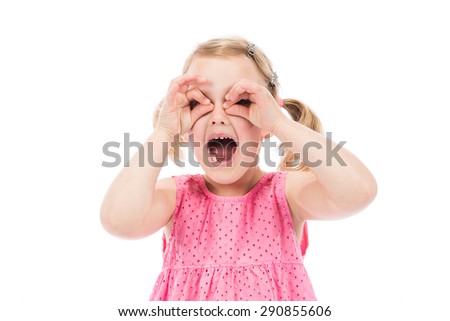Children's real emotions. Little girl looking through imaginary binocular.