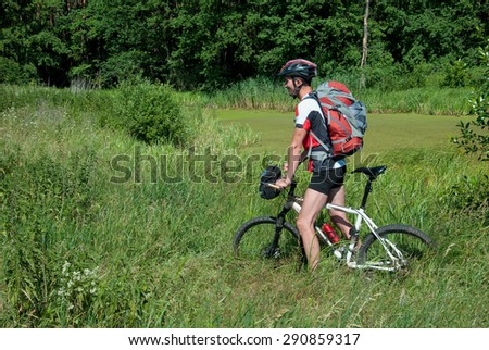 Cyclist practicing mountain bike on a forest trail. The rider is back