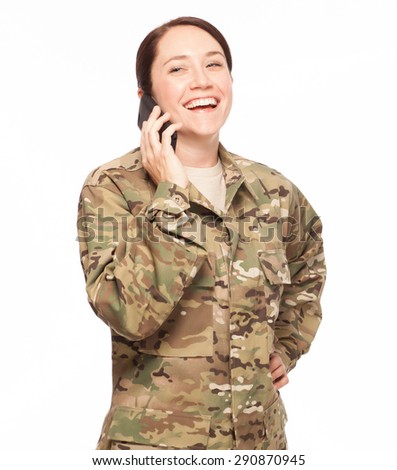 Female Army soldier laughing on phone while wearing multicam camouflage.