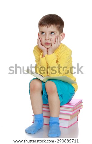 A little boy dreams of reading a book - isolated on white background
