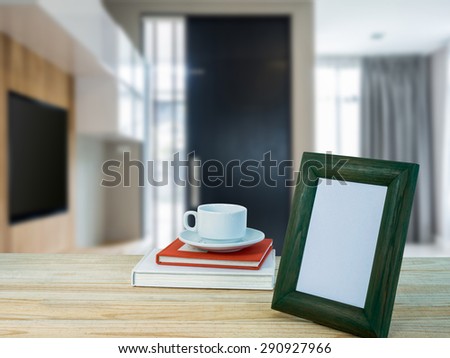 Photo frame, coffee cup on wooden counter top with modern office blurry background