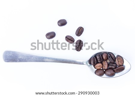 Dark roasted coffee beans and spoon isolated on white background