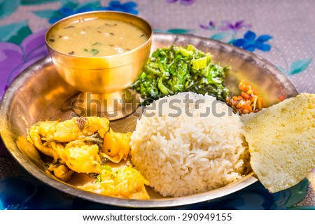 Dal Bhat, traditional Nepali meal platter with rice, lentils soup, vegetables, poppadum and spices. Royalty-Free Stock Photo #290949155