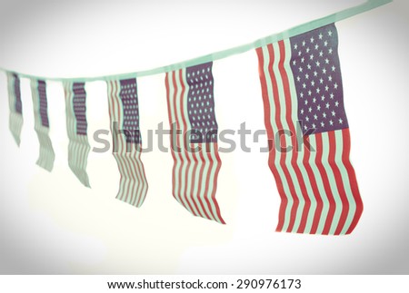 A chain / garland/ bunting of USA flags hanging proudly for July 4 Independence Day - vintage / retro / Instagram processed