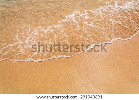 Sea waves roll on yellow fine sand while on vacation