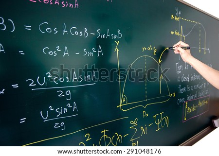 Closeup of hand writing complicated math equation on black board. Royalty-Free Stock Photo #291048176