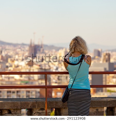 The girl photographer in Barcelona. Girl tourist photographs panorama of the city of Barcelona. Spain.