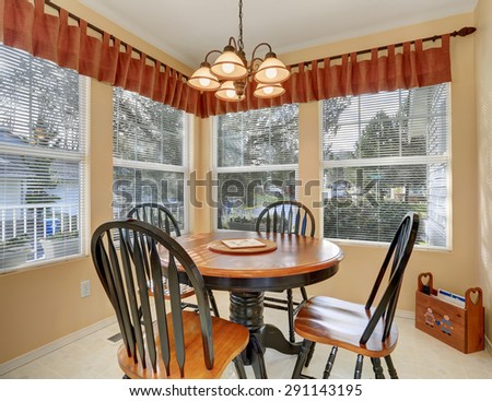 Simple dinning room with tile floor, and windows.