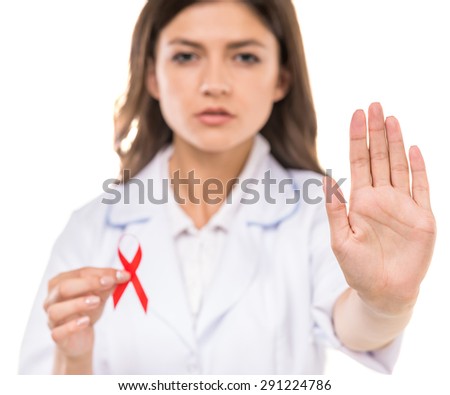 Beautiful female doctor holding red ribbon as a symbol of AIDS.